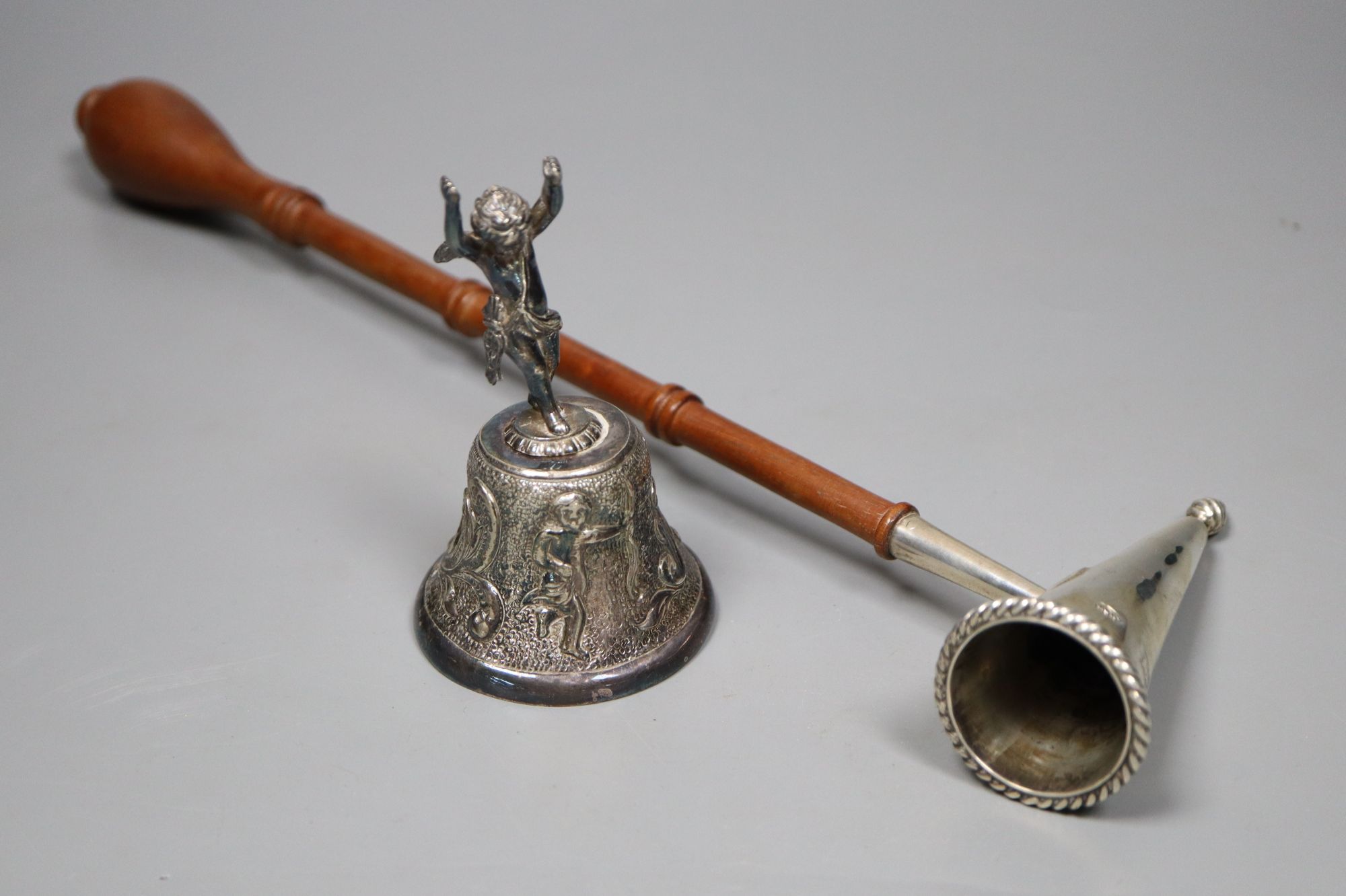 A modern silver table bell with putti handle, and a modern silver and turned wood handle candle snuffer,